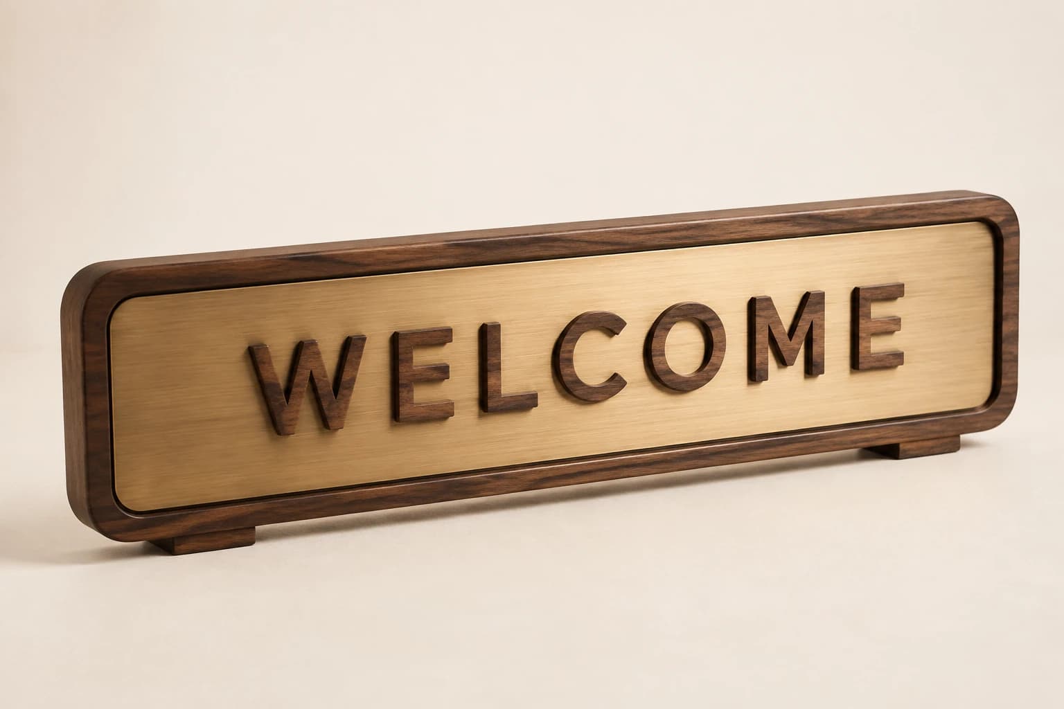 Wide walnut welcome sign with an inset brushed brass face and raised lettering.